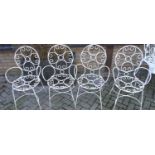 A set of four white painted wired metal garden elbow chairs