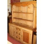 A Victorian rustic pine round cornered kitchen dresser, the two-tier open plate rack over base