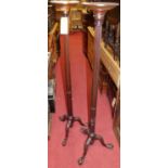 A pair of early 20th century mahogany stop fluted torchere stands, each raised on acanthus leaf