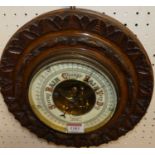 An early 20th century floral relief carved walnut circular aneroid barometer, signed Blackham