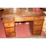 An early 20th century hardwood kneehole writing desk, having an arrangement of nine drawers, width