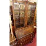 A 1930s oak bureau bookcase, having twin glazed upper doors, width 91cm