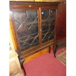 An early 20th century mahogany double door astragal glazed bookcase on stand, raised on acanthus