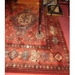 A large contemporary Persian style European manufactured red ground machine-made woollen Bokhara