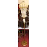 A gilt decorated tubular metal standard lamp, with a blown yellow glass shade within wirework