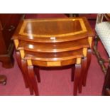 A reproduction mahogany and burr oak inlaid bow front nest of three occasional tables, the largest