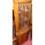 A reproduction mahogany corner cabinet, having glazed upper door