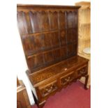 An early 20th century geometric oak dresser, having two-tier open plate rack over three frieze