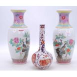 A pair of Chinese Canton famille rose vases, enamel decorated with birds amongst flowers, enamel