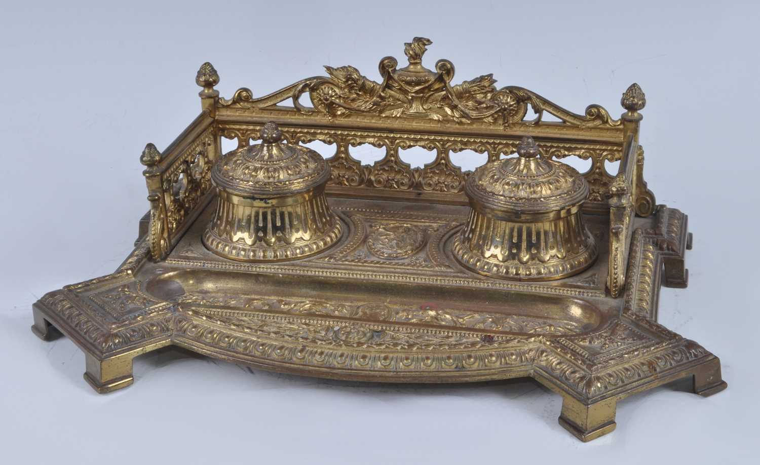 A late 19th century French gilt bronze encrier, the raised and pierced three-quarter gallery with