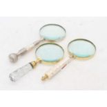 Three various table magnifying glasses, the largest 26cm