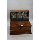 An early 20th century oak cased three decanter tantalus, w.33cmDecanters are replacements, as are