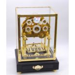 A reproduction brass congreve clock, having six enamel dials and rolling ball movement, housed
