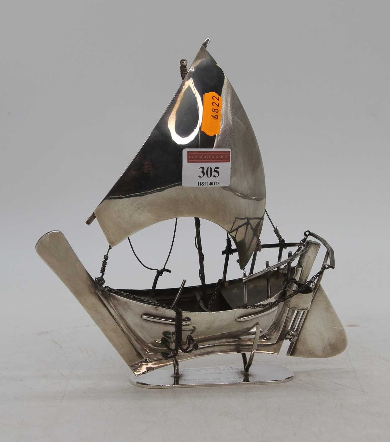 An Arabian white metal model of a dhow boat, mounted upon a presentation stand, stamped silver to
