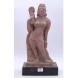 An Eastern carved sandstone figure of a lady, mounted upon an ebonised plinth, h.43cm