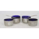 A set of four Victorian silver table salts, in the Indian taste, each having a blue glass liner,