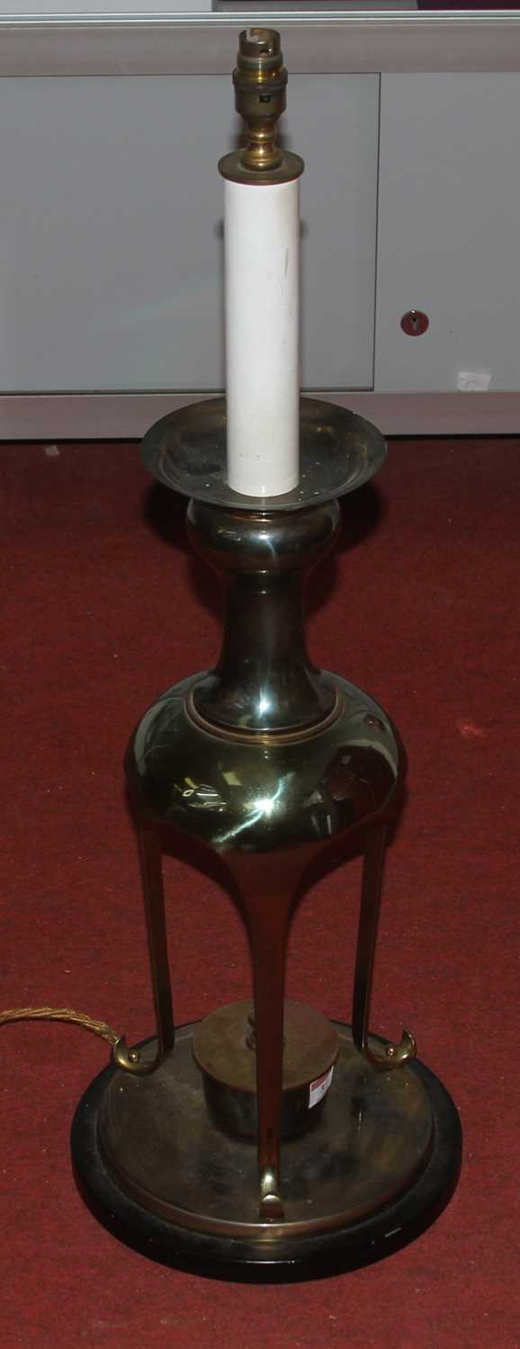 A large 20th century brass table lamp, standing upon a tripod base and ebonised plinth, h.84cm