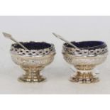 A pair of Victorian silver table salts, each having blue glass liner and matched spoons, London