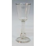 A large Georgian wine glass, the round funnel bowl above a teared baluster stem and folded foot, h.