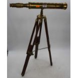 A brass telescope, mounted upon a hardwood tripod stand, h.45cmSlightly dented.Missing lens cap.