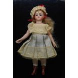A late 19th century French all bisque Mignonette doll, having fixed blue glass eyes with painted