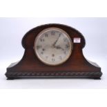 An early 20th century oak cased mantel clock, the silvered dial showing Arabic numerals, the eight-