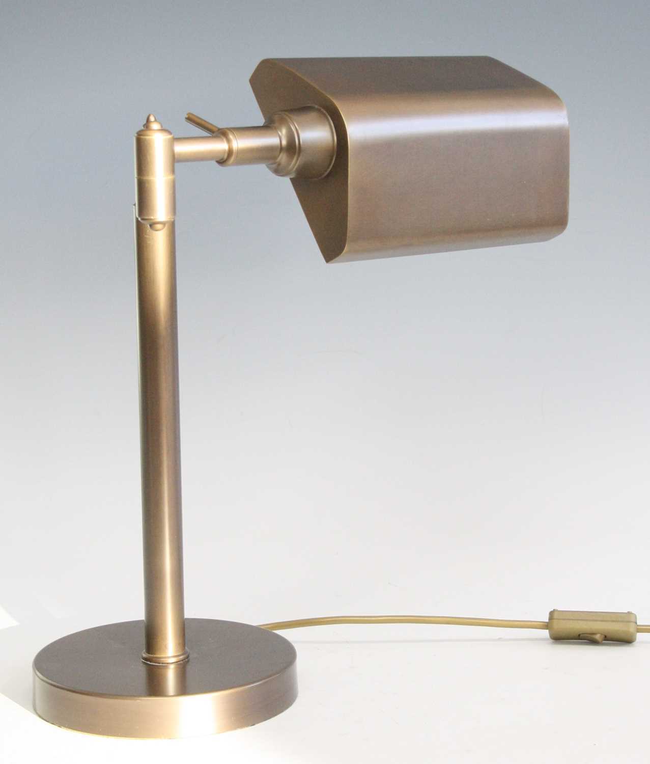 A contemporary brushed brass banker's desk lamp, having adjustable shade and branch arm, raised on