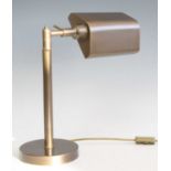 A contemporary brushed brass banker's desk lamp, having adjustable shade and branch arm, raised on