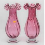 A pair of Victorian style cranberry glass vases, each having a frilled rim, height 37cm