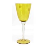 An oversized wine glass, the yellow round funnel bowl above an air twist stem, height 33cm