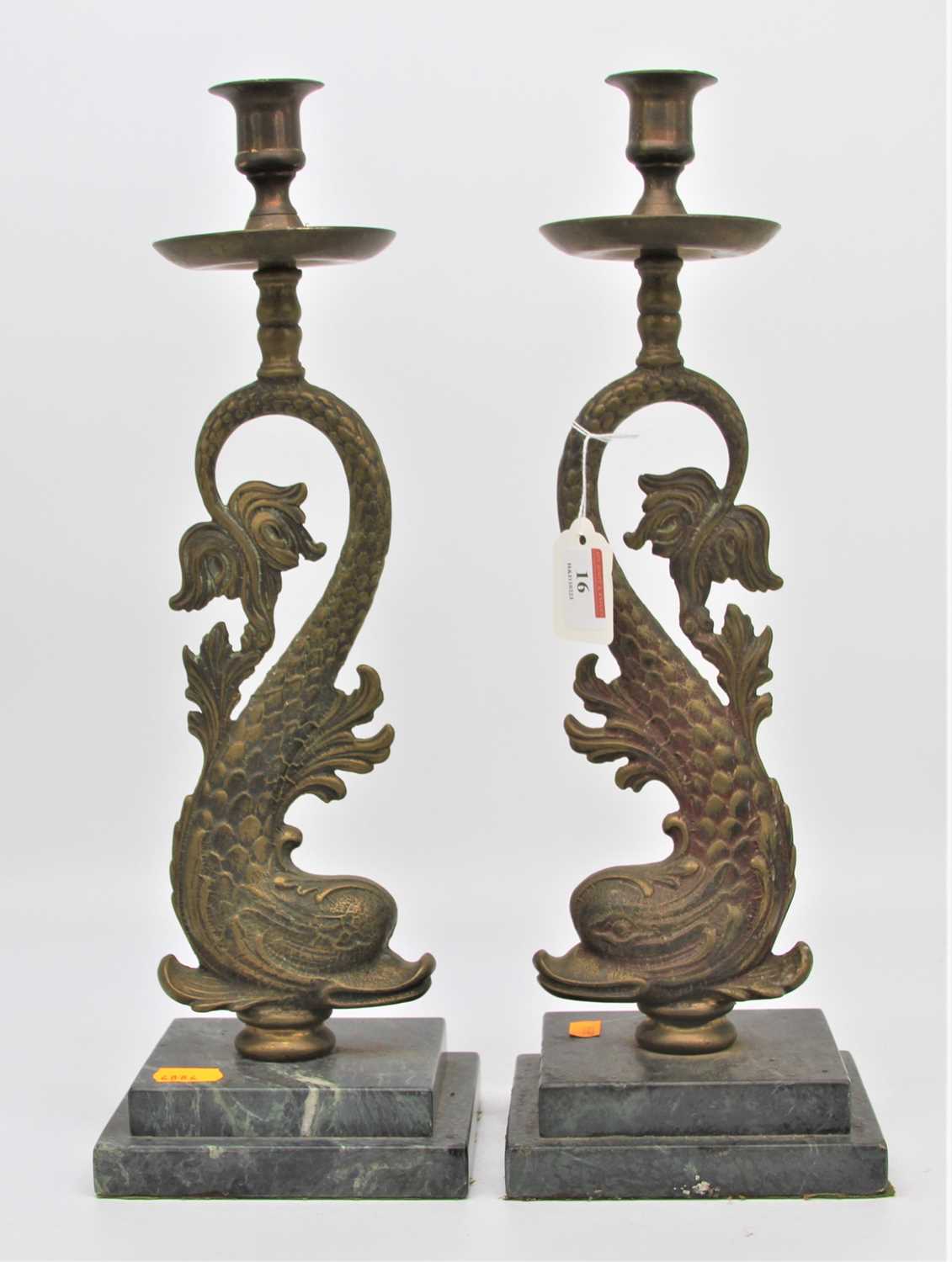 A pair of 19th century brass candlesticks, each in the form of a dolphin, mounted upon a stepped