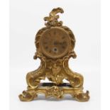 A 19th century French Rococo revival gilt brass mantel clock, the engine turned decorated dial