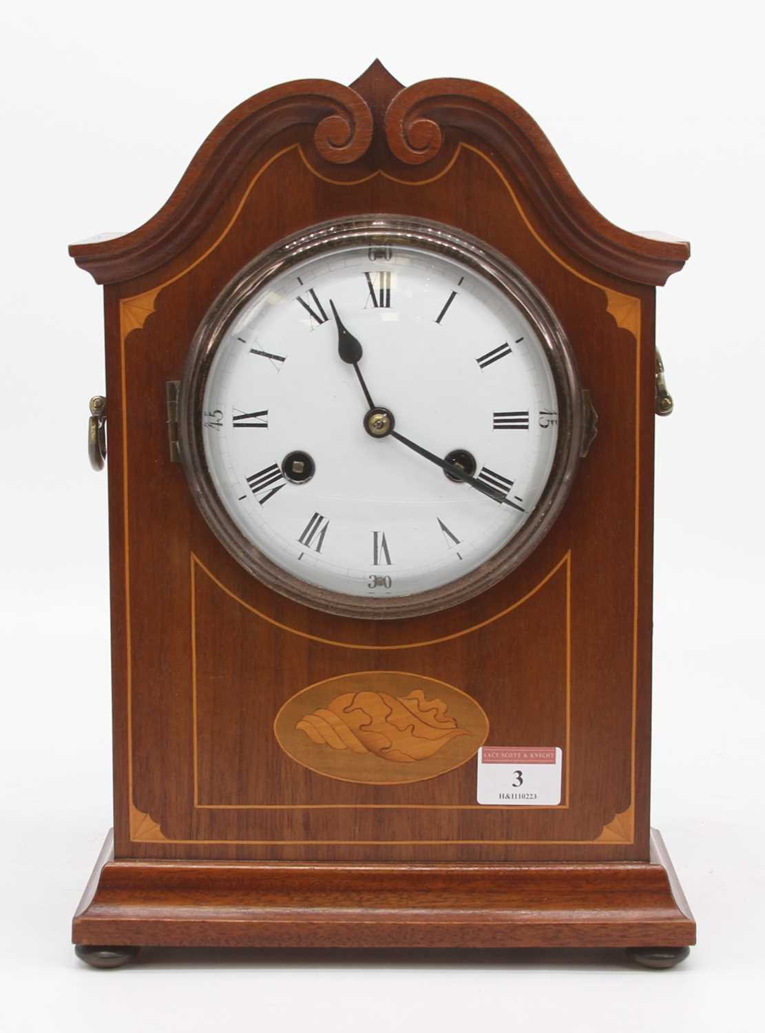 An early 20th century mahogany and box wood strung mantel clock, the enamel dial showing Roman