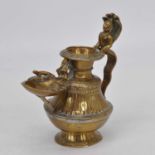 A Nepalese gilt copper oil lamp, having figural handle, height 15cm