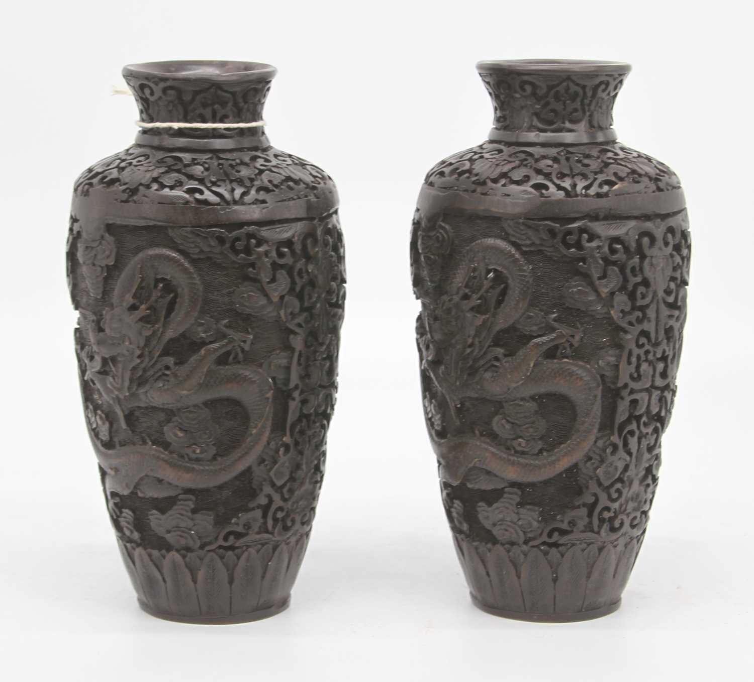 A pair of Chinese carved resin vases, each decorated with a dragon, height 23cm