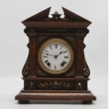 An early 20th century oak cased mantel clock, the enamel dial showing Roman numerals, having an