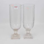 A pair of cut glass hurricane lamps, the elongated bowls above a rudimentary stem and stepped