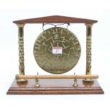 A Burmese oak and brass table gong, height 24cm