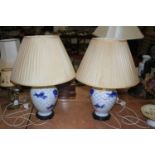 A pair of Chinese blue & white table lamps, each decorated with fish, and having a pleated silk