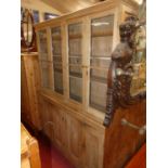 A Victorian pine bookcase cupboard, having four glazed upper doors over conforming lower panelled