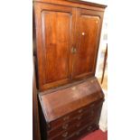 An early 19th century provincial oak bureau cabinet, w.105cm