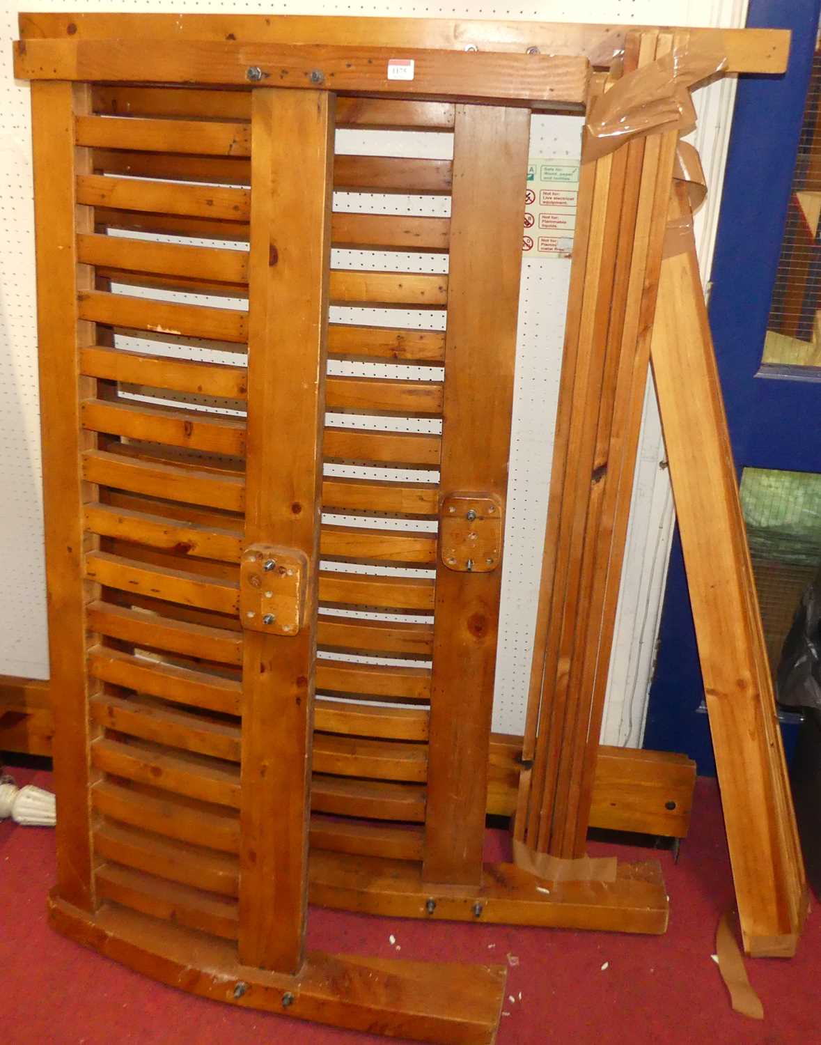 A contemporary stained pine slatted double bedstead with side rails and slats