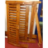 A contemporary stained pine slatted double bedstead with side rails and slats