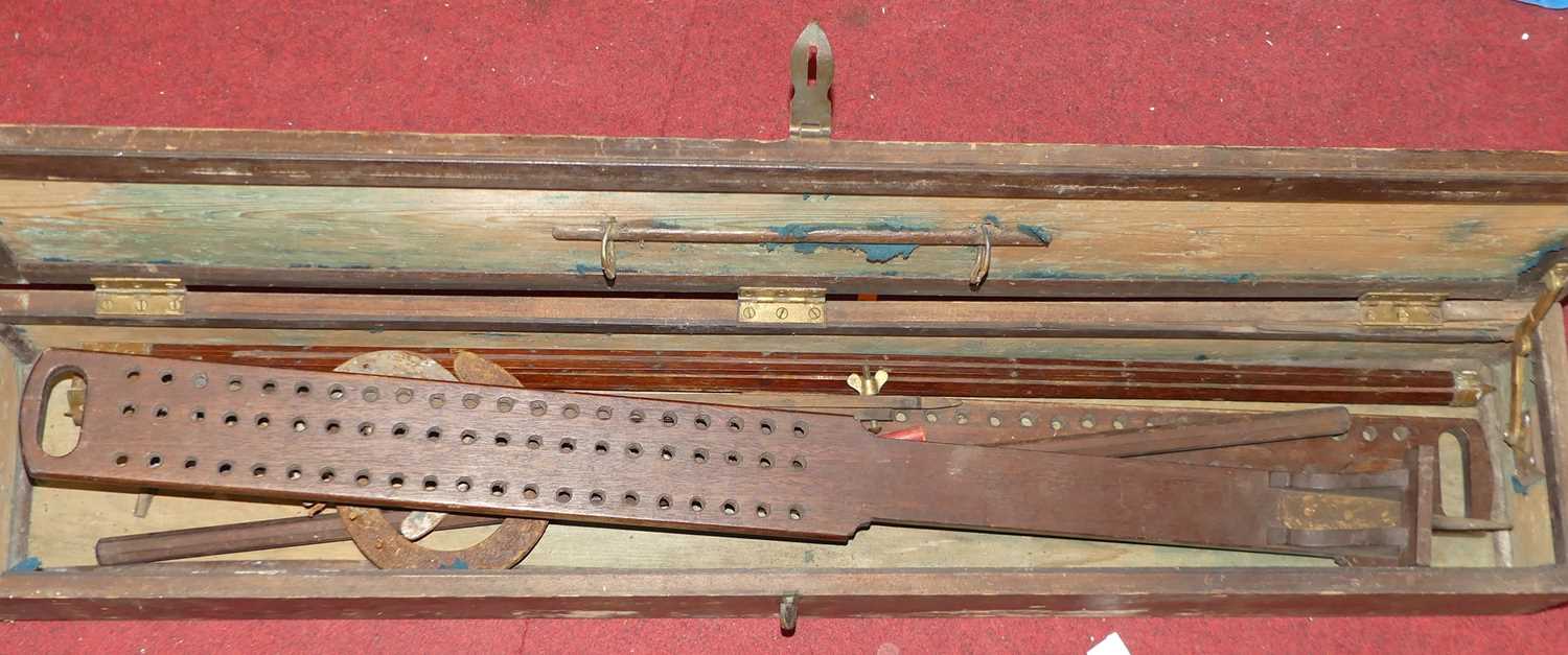 A stained pine hinged box containing two timber drawplates, metal horseshoes etc