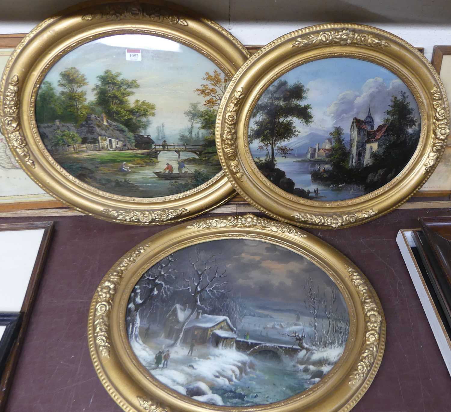 A set of three early 20th century reverse paintings on glass, being boating and landscape scenes,