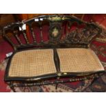 A late Victorian black painted floral polychrome and gilt decorated cane inset two-seater salon