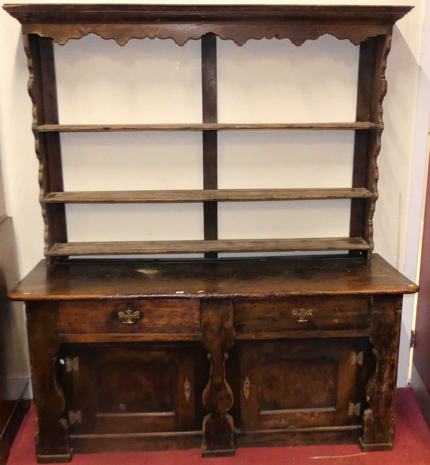 A provincial 18th century joined elm and fruitwood dresser, the later three-tier rack over unusual