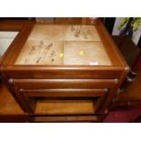 A 1970s teak and tile inset nest of three occasional tables, the largest w.54cm