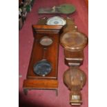 An oak aneroid wheel barometer; together with a 19th century mahogany clock barometer case, an oak