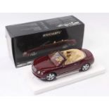 A Minichamps 1/18 scale model of a Bentley Continental GTC 2006 saloon, finished in metallic red,